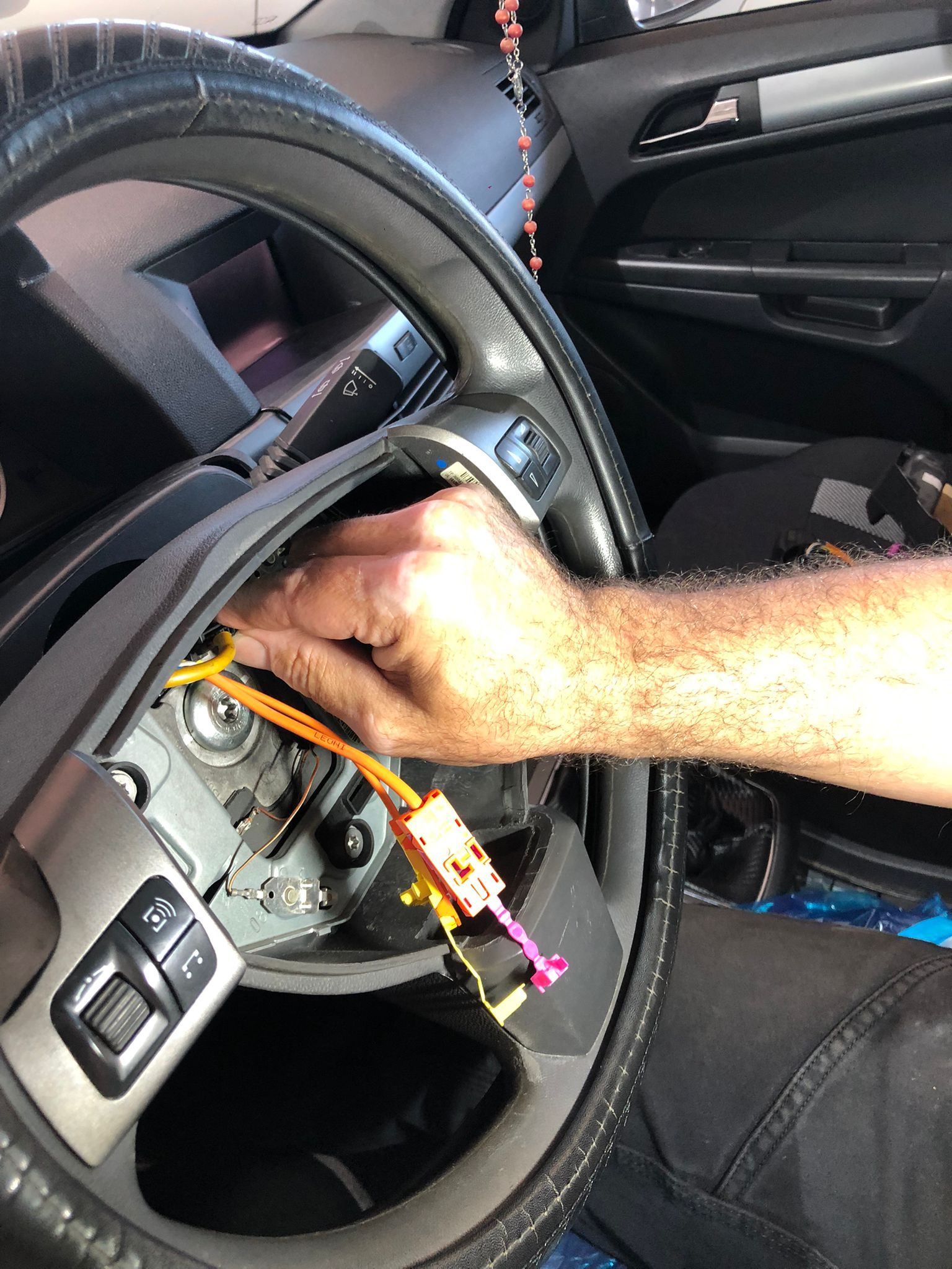 🚘 Avería en Opel Astra: Claxon no funciona al encender luces de posición o cruce (sin códigos de error) – Caso real resuelto en GuemaCAR En Soluciones GuemaCAR Laboratorio Electrónica Automotriz, situado en Calle Newton, Edificio 2, Nave 1, 28914, Leganés, Madrid, recibimos este Opel Astra con una avería eléctrica muy peculiar: 👉 El claxon (bocina) dejaba de funcionar al encender las luces de posición o cortas. ❌ El coche no presentaba ningún código de avería en centralita ❌ No pasaba la ITV debido a esta anomalía de seguridad. 🔍 Diagnóstico inicial En nuestra zona de diagnosis avanzada detectamos lo siguiente: El claxon funciona correctamente con luces apagadas. Al encender cualquier posición de luz (posición o cruce), el claxon queda completamente inactivo. No hay fallos en la ECU de motor, ni en UCH/BCM (unidad de carrocería). Ninguna luz de advertencia en el cuadro. Fusibles y relé de bocina comprobados y operativos. 🧠 ¿Qué puede causar esto en un Opel Astra? Esta avería suele deberse a un fallo en el módulo de la cinta espiral (clock spring / "clockspring"), también conocida como unidad de contacto giratorio. Este componente se encarga de mantener la conexión eléctrica entre el volante y los sistemas de airbag, claxon, mandos de control de luces, etc. 👉 En este caso concreto, al desmontar la zona del volante, se evidenció que la unidad de contacto rotativo (fabricada por VALEO, ref. 13198906) estaba dañada internamente. 🛠️ Proceso de reparación (con imágenes del caso real) Durante la intervención, el equipo técnico: Desmontó el airbag y volante con total seguridad (sistema con conectores amarillos y púrpura, habituales en sistemas de retención). Accedió a la unidad de contacto giratorio defectuosa. Se comprobó que el circuito interno tenía cortes intermitentes, probablemente por desgaste o microfisuras en las pistas flexibles. Se reemplazó la pieza defectuosa por una nueva original o reparada con garantía. Se rearmó todo con torque especificado, y se hizo recentrado del clock spring (etiqueta de fábrica “RE-CENTER”). 📸 Las imágenes del proceso muestran claramente la manipulación experta de la pieza, conectores, y herramientas usadas durante la reparación. ✅ Resultado final El claxon volvió a funcionar con y sin luces encendidas. El vehículo pasó ITV sin incidencias. Cliente satisfecho y agradecido por localizar una avería que no había sido resuelta por otros talleres. Sin necesidad de reprogramar centralitas ni reemplazar unidades electrónicas costosas. 💡 ¿Tienes un Opel Astra u otro vehículo con averías eléctricas raras como esta? En Soluciones GuemaCAR Laboratorio Electrónica Automotriz somos especialistas en: ✔️ Reparación de módulos electrónicos ✔️ Diagnóstico avanzado sin cambiar piezas al azar ✔️ Casos difíciles sin código de error ✔️ Reparación de BCM, CIM, ECU, UCH, EZS y más 📍 Calle Newton, Edificio 2, Nave 1, Leganés (Madrid) 📞 Contáctanos para cita previa o consulta técnica. 🔧 ¡Tu coche en manos expertas, sin cambiar piezas innecesarias!