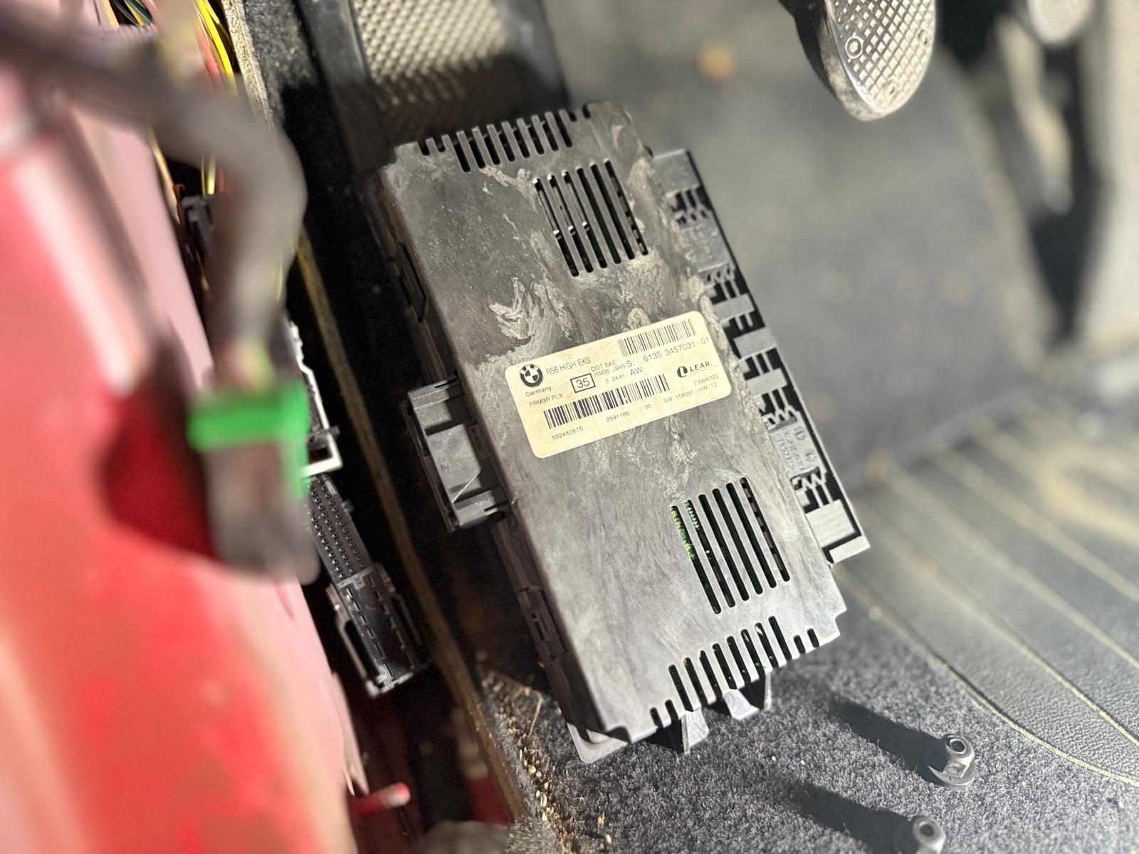 El módulo FRM (Footwell Module) en los Mini está ubicado normalmente en la zona inferior del lado del conductor, justo detrás de la guantera lateral o en la parte baja del pilar A, en el área conocida como footwell o espacio para los pies.